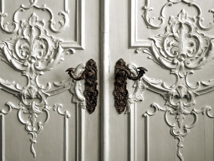 Elegant vintage door handles on a carved wooden door enhanced with Fairway Divorce Solutions mediation agreements.